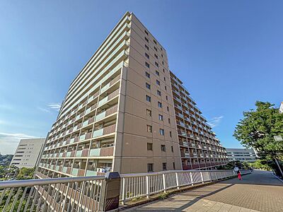 外観：空に映える大規模レジデンス。広々とした歩道と豊かな緑に囲まれ、お子様との散歩も快適です。家族の笑顔が育つ、安心の住環境がここにあります。
