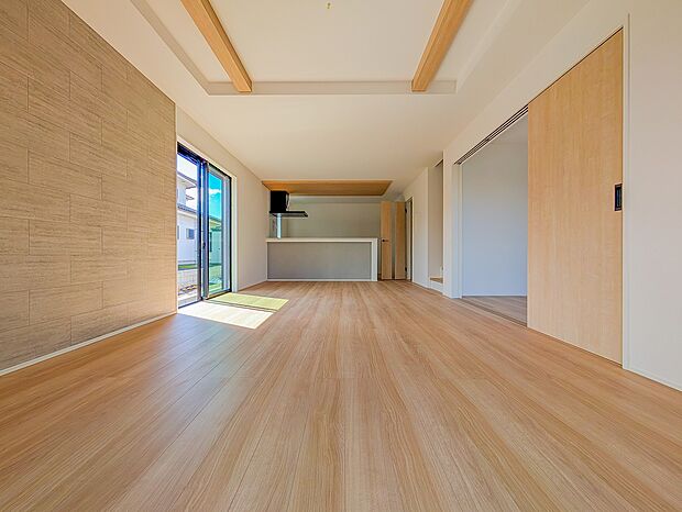 キッチン上の折り下げ天井がアクセントの洗練されたデザイン。木目と白を基調とした心安らぐリビングです。
