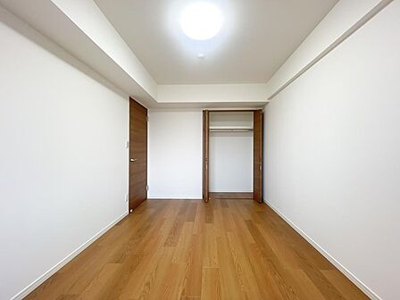 木の温もりを感じるナチュラルな洋室。枕棚とハンガーパイプを備えた大容量収納でお部屋もすっきり。
