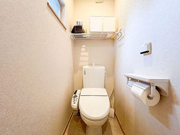 清潔感あふれるトイレは、窓からの光で明るく快適な空間です。便利な棚やウォシュレット機能も完備し、家族みんなが気持ち良く使えます。