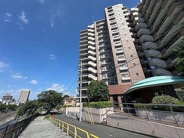 青空が広がる開放的な立地。堂々と佇む高層マンションと川沿いの散歩道は、家族の健康的な毎日を育みます。