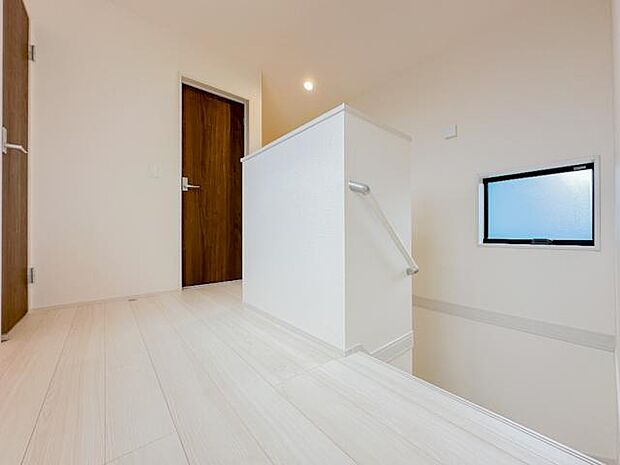 白を基調とした内装に木目調の建具を合わせた2階ホール。階段部分には手すりを備え、窓から自然光を取り込める設計です。各居室へとつながる、すっきりとした動線が確保されています。