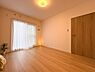 寝室：バルコニーに面した明るいお部屋。木目調の建具が温もりある空間を演出します。