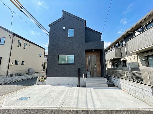 角地に面した住まいは、二方向に開けた配置ならではの開放感が魅力です。印象的な屋根形状と落ち着いた外壁が建物を引き立てます。掃き出し窓も設けられ、室内へ自然光を取り込みやすい設計です。