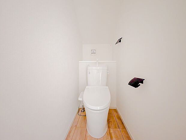 白を基調とした空間に、黒のペーパーホルダーとタオル掛けを合わせたスタイリッシュなトイレです。