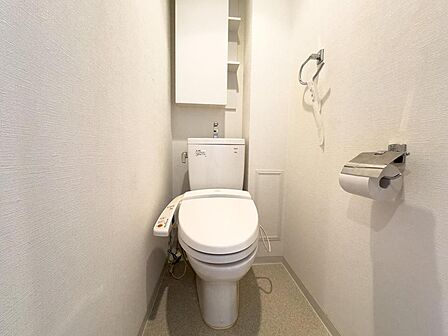 白を基調とした清潔感あふれるトイレは、温水洗浄便座と便利な上部収納を完備。家族みんなが快適に使える、機能的な空間です。