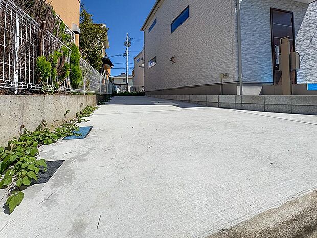広々としたコンクリート敷きのカースペース。前面道路との段差も少なく、スムーズな入出庫が可能です。