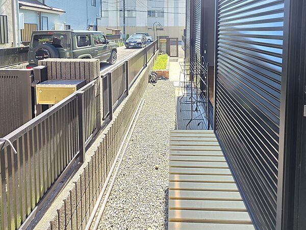 建物脇には奥行きのあるスペースが確保され、通路としてゆとりをもって使えます。砂利敷きで管理もしやすく、ガーデニング用品や屋外用品の一時置き場など、暮らしに合わせて活用できるスペースです。