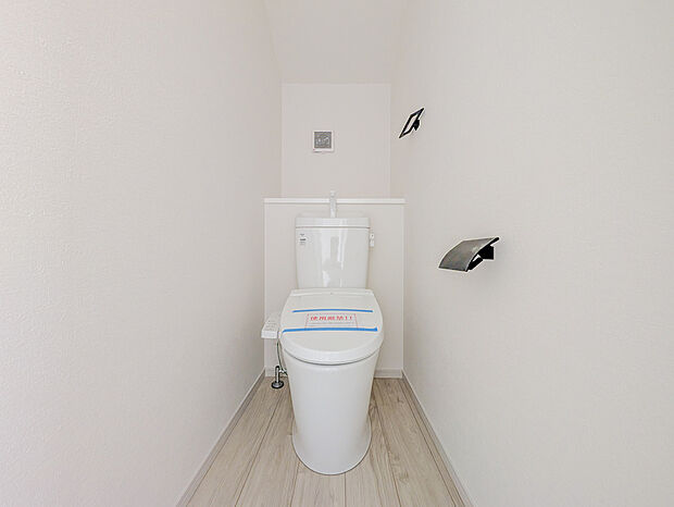 白を基調とした空間に、黒のペーパーホルダーとタオル掛けを合わせたスタイリッシュなトイレです。