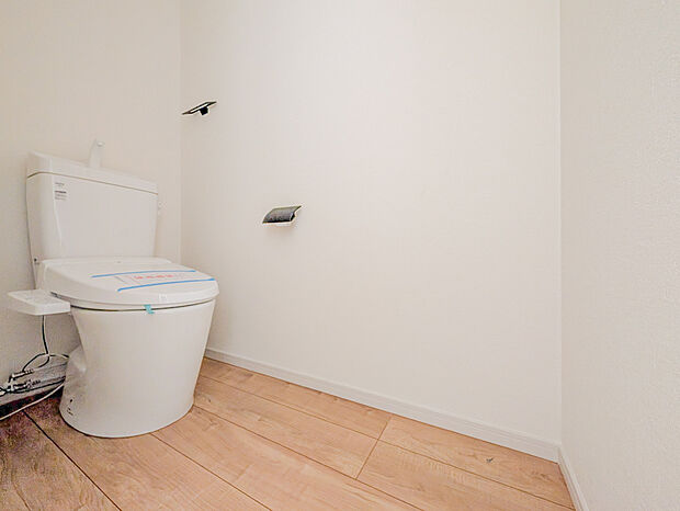 白を基調とした空間に、黒のペーパーホルダーとタオル掛けを合わせたスタイリッシュなトイレです。