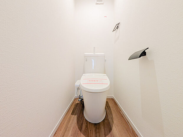 白を基調とした空間に、黒のペーパーホルダーとタオル掛けを合わせたスタイリッシュなトイレです。