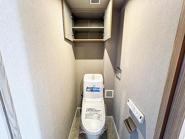 最新式の機能が充実したトイレは、壁リモコンで操作も快適です。上部収納でトイレットペーパーなどのストックもすっきり片付き、清潔な空間を保てます。