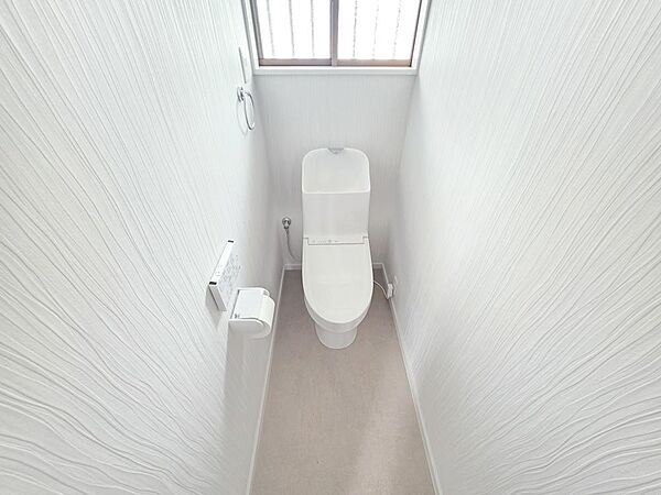 新規交換されたトイレは、温水洗浄機能を備えた使いやすい設備です。窓から自然光を取り込みやすく、換気にも配慮されています。壁紙や床も整えられ、毎日気持ちよく使用できる清潔感のある空間です。