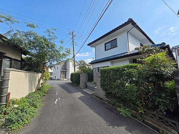 建物周辺は低層住宅が並ぶ落ち着いた街並みが広がっています。前面道路は車通りも比較的少なく、住環境の穏やかさを感じられます。緑のある住宅が点在し、日々の暮らしをゆったりと送れる周辺環境です。