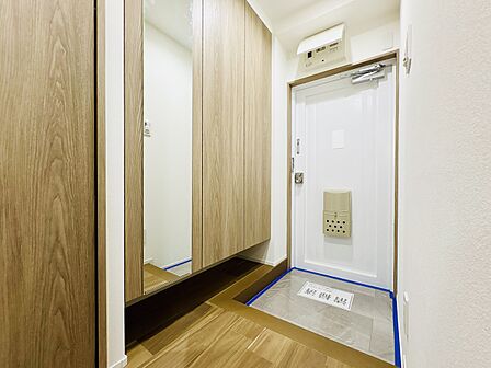 人感センサー付き照明を設置した玄関。お出かけ前の身だしなみチェックに便利な姿見鏡付きの収納です。