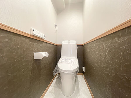 シックなツートンクロスがおしゃれなトイレ空間!温水洗浄便座完備で毎日快適に使用できます。