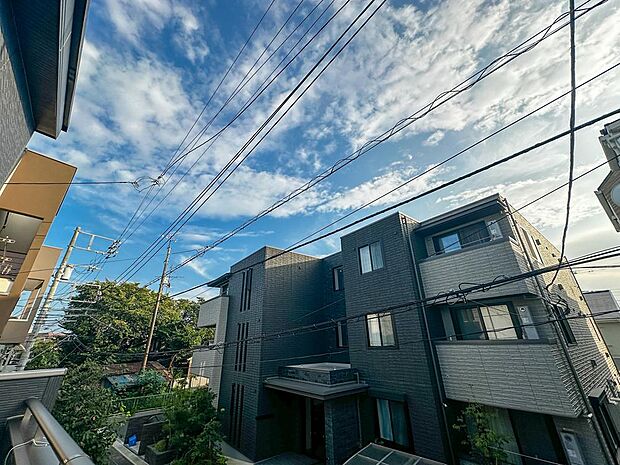 大きな青空と穏やかな街並みが広がるバルコニーからの眺望。前面が開けているため陽光や爽やかな風がしっかり届きます。静かで落ち着いた周辺環境で、毎日の暮らしにゆとりと癒やしをもたらす心地よいロケーションで
