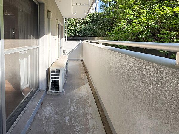 目の前に植栽が広がるバルコニーは、身近に緑を感じられる場所です。掃き出し窓から出入りでき、洗濯物を干す際も室内からスムーズに移動できます。上部には物干し金具が備わっています。