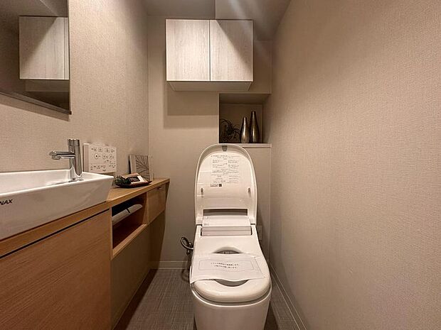 温水洗浄便座付きのトイレです。独立型の手洗いカウンターが備わっています。