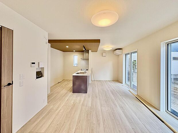 大きな窓のある開放感のあるリビングスペース。キッチンの天井は、折り下げ天井が採用されています。