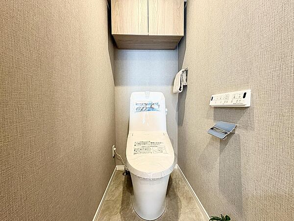 温水洗浄便座が備わっており、毎日快適にご使用いただけます。掃除用具の収納に便利な吊り戸棚付きです。