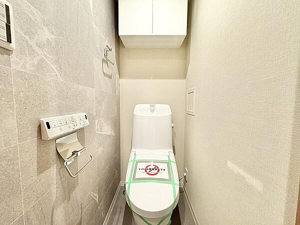 温水洗浄便座が備わっており、毎日快適にご使用いただけます。掃除用具の収納に便利な吊り戸棚付きです。