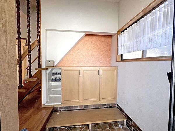 オレンジの壁紙がワンポイントとなって昭和レトロを感じさせるオシャレな玄関＆ホールです。