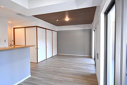 木目調の天井がアクセントの、スタイリッシュなお部屋。グレーのアクセントクロスが落ち着いた雰囲気を演出します。和の趣を感じさせる引き戸も魅力的。明るい陽射しが差し込む、心地よい空間です。