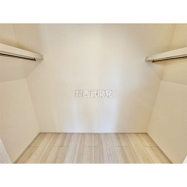 両側にハンガーパイプが備え付けられた大容量のウォークインクローゼットをご用意いたしました。