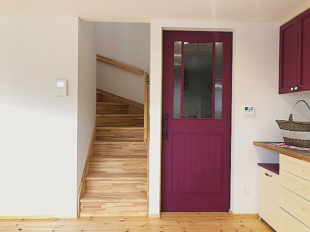 玄関からキッチン、そして2階へとつながる、ムダのないシンプルな動線。暮らしに寄り添う設計です。印象的なのは、深みのあるボルドーの木製ドア。空間のアクセントになり、可愛さと上質さを両立しています。