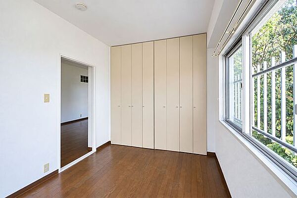 壁一面に収納を備えた6帖の洋室。衣類や小物をまとめてしまえるので、家具を増やしすぎず、お部屋をすっきり使えます。