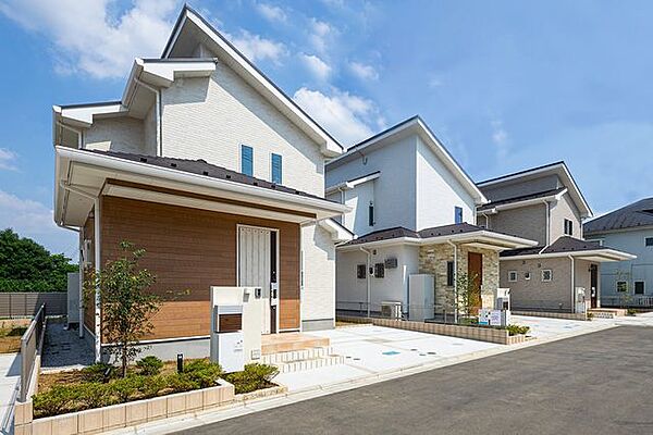 【　住協建設の施工例　】青空に映える、白と木目のコントラスト。 素材感のある木目調パネルがアクセントに。明るく開放感あふれるデザインが、日々の暮らしを軽やかに彩ります。