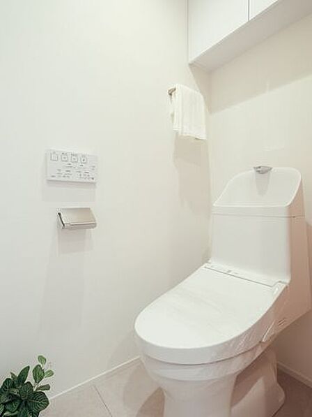 シンプルで安らぎが宿るレストルームです。吊戸棚にはトイレットペーパーや掃除用具を収納できるので便利です。