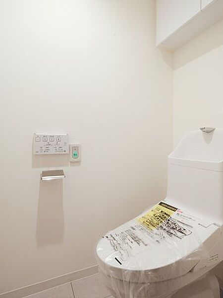 シンプルで安らぎが宿るレストルームです。吊戸棚にはトイレットペーパーや掃除用具を収納でき、生活感を抑えたすっきりとした空間を保てます。