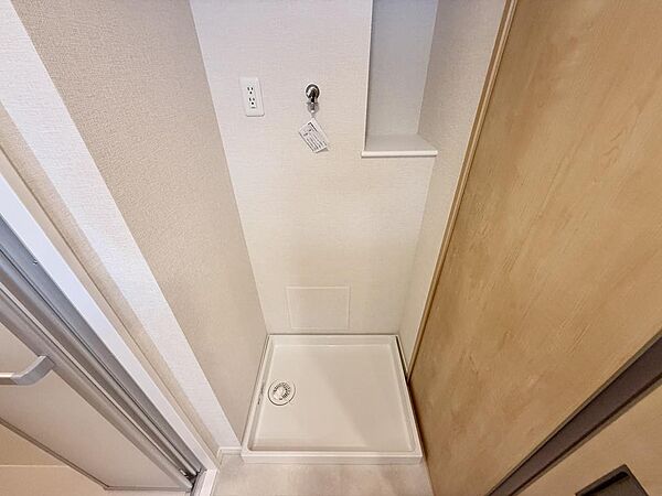 室内に設けられた洗濯機置き場です。棚もあり洗剤などのストックを置けます