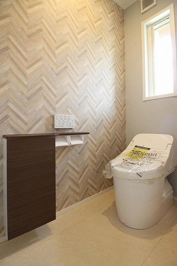 収納とトイレットペーパーホルダー付きです。ヘリボーン柄のクロスがアクセント♪