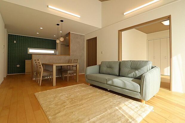 16.7帖のLDK。リビング上部は勾配天井になっており南側からの明るい日差しが入ってきます。掃き出し窓を出ると、ウッドデッキに繋がります。隣接には4.5帖の和室もあります。家具、照明、カーテン付。