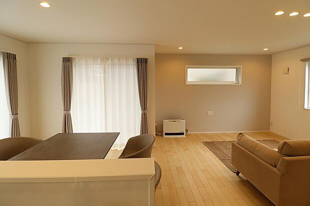 LDK18.2帖の広い空間。室内にある家具、リビングエアコン、ガスファンヒーター、カーテンはそのままのお引渡し。フローリングは自然な色合いで、傷や汚れが目立ちにくいです。掃き出し窓にはウッドデッキ付。