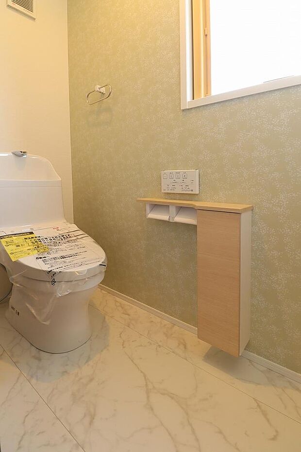 1階はタンクレストイレ。節水型でお掃除も楽々。収納棚も付いているので足元空間も広々。