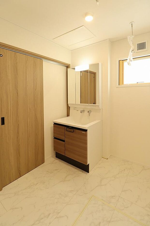 洗面室。3面鏡の洗面化粧台で収納力もあるので身だしなみもしっかりチェックできます。室内にホスクリーンもあるので室内干しもできます。