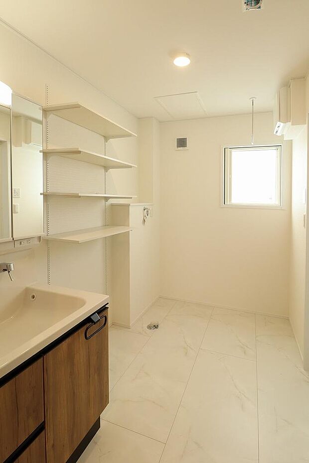 3面鏡の洗面化粧台が備えついています。収納棚もついているので、バスタオルや衣類を収納できて便利です。