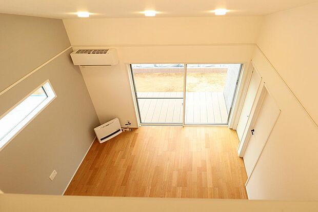 リビング上部は吹抜けとなっています。リビングエアコン、ガス暖房も設備として設置されています。掃き出し窓は自動シャッターとなっています。