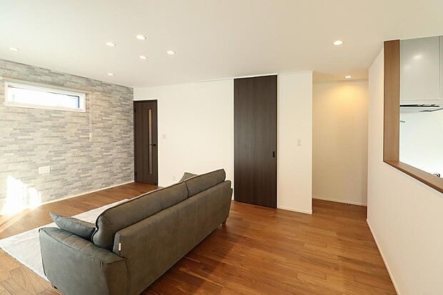 リビングのテレビ設置側の壁にはアクセントクロスでお洒落になっています。リビング隣接の掃き出し窓を出るとウッドデッキに繋がります。自動シャッターでスマホで開け閉め可能。