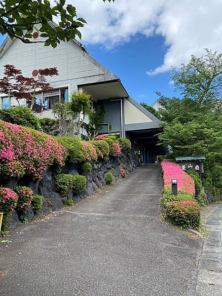 【建物外観】春にはつつじが美しいスロープを上がれば、保養所としてご利用いただける大型レジデンスがございます。