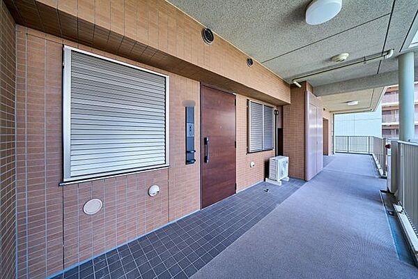 ゆとりある共用廊下はきれいに管理され、重厚感のある玄関ドアが落ち着いた雰囲気を演出します。