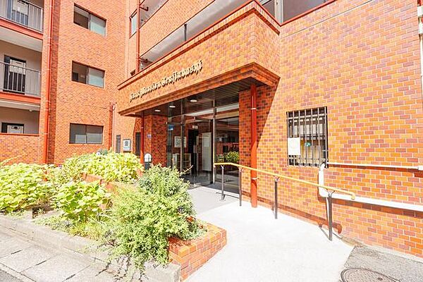 植栽に彩られたアプローチの先には、手すりを備えた安心感のあるエントランス