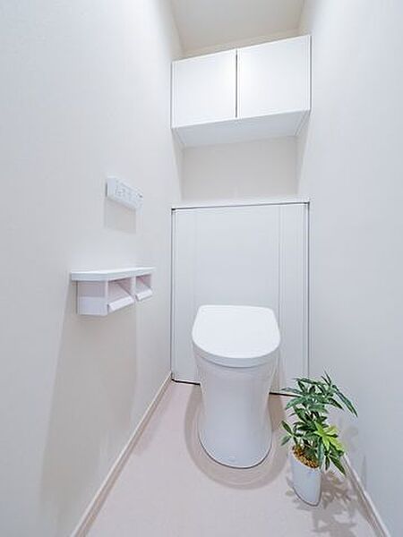 スタイリッシュで快適な温水洗浄便座付きトイレ。上部にはトイレットペーパーなどを収納出来る吊戸棚付き。※室内の家具や調度品は、売買代金には含まれません。
