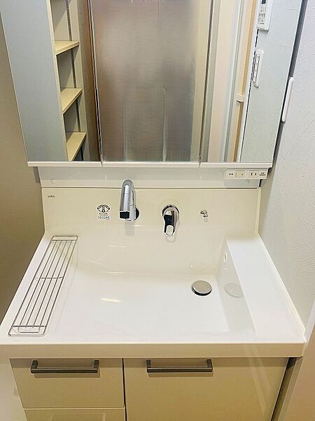 ３面鏡付きのシャンプードレッサー新調しました。洗濯機置き場もある広々とした洗面室です。（洗濯パン・洗濯用水栓新調、クロス・ＣＦ張替等）