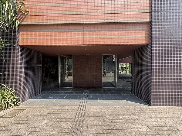 ブラウン基調のシックなタイル貼りと重厚感あふれる木調ドアが迎えるメインエントランス。美しく整えられた足元の植栽とアプローチが上質な佇まいを演出し、住まう方を誇らしく導くタワーレジデンスの顔です。