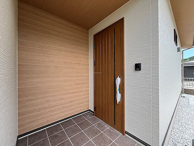 木目調の玄関ドアと外壁のコントラストが美しい玄関です。帰宅するたびに気持ちが安らぐデザインが魅力。屋根もあり雨の日も濡れにくいです
